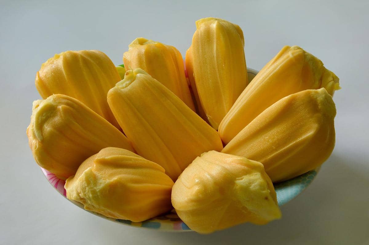 Daging buah nangka berwarna kuning keemasan tersusun rapat, memperlihatkan tekstur lembut, tebal, dan tampak segar.
