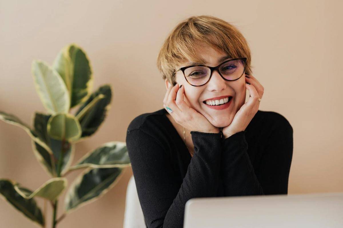 Seorang wanita sedang tersenyum.