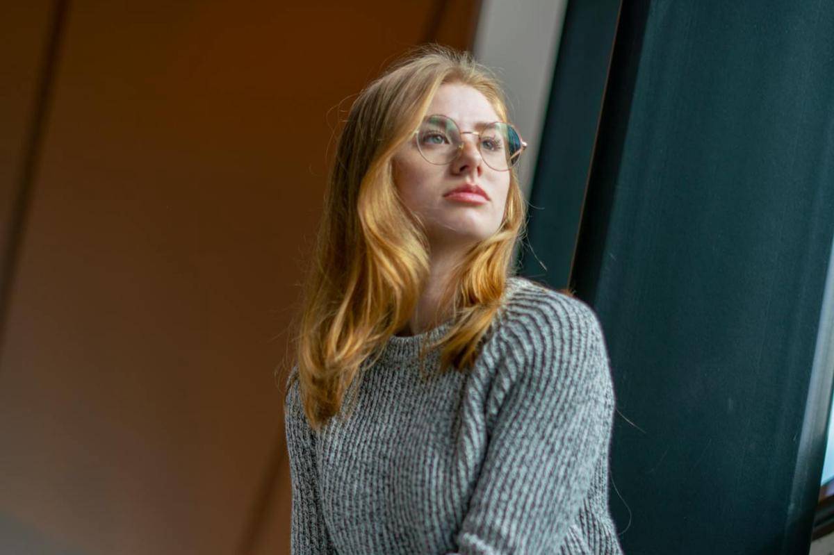 Seorang wanita sedang duduk di dalam ruangan.