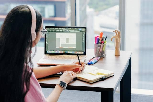 Perempuan bekerja sambil mendengarkan musik