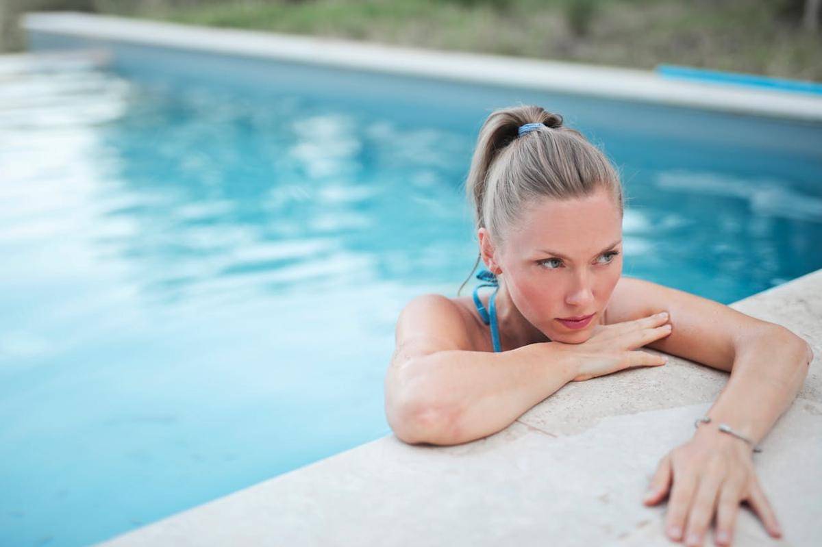 Seorang wanita sedang di pinggir kolam.