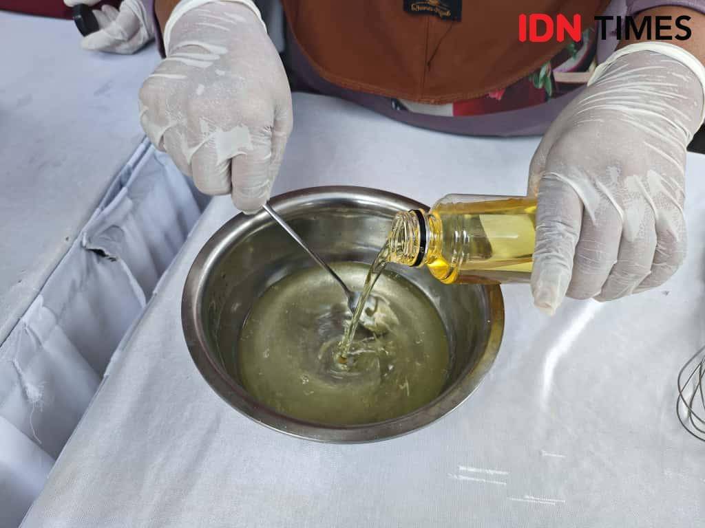 Proses pencampuran minyak kelapa ke dalam air destilasi yang sudah dilarutkan soda api. (IDN Times/Febriyanti Revitasari)