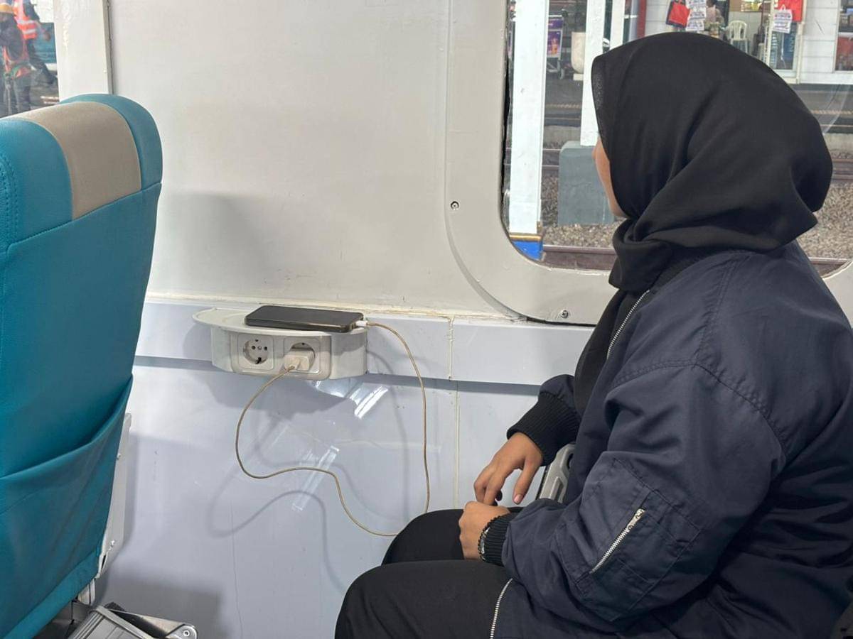 Penumpang menggunakan fasilitas colokan listrik di dalam kereta di Semarang. (Dok. KAI Daop 4 Semarang)