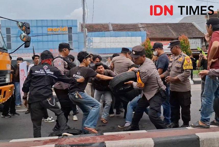 Polisi dan massa aliansi Freedom saling rebutan ban bekas saat peringatan hari sumpah pemuda di Jl Sultan Alauddin Makassar, Selasa (28/10/2025). IDN Times/Darsil Yahya