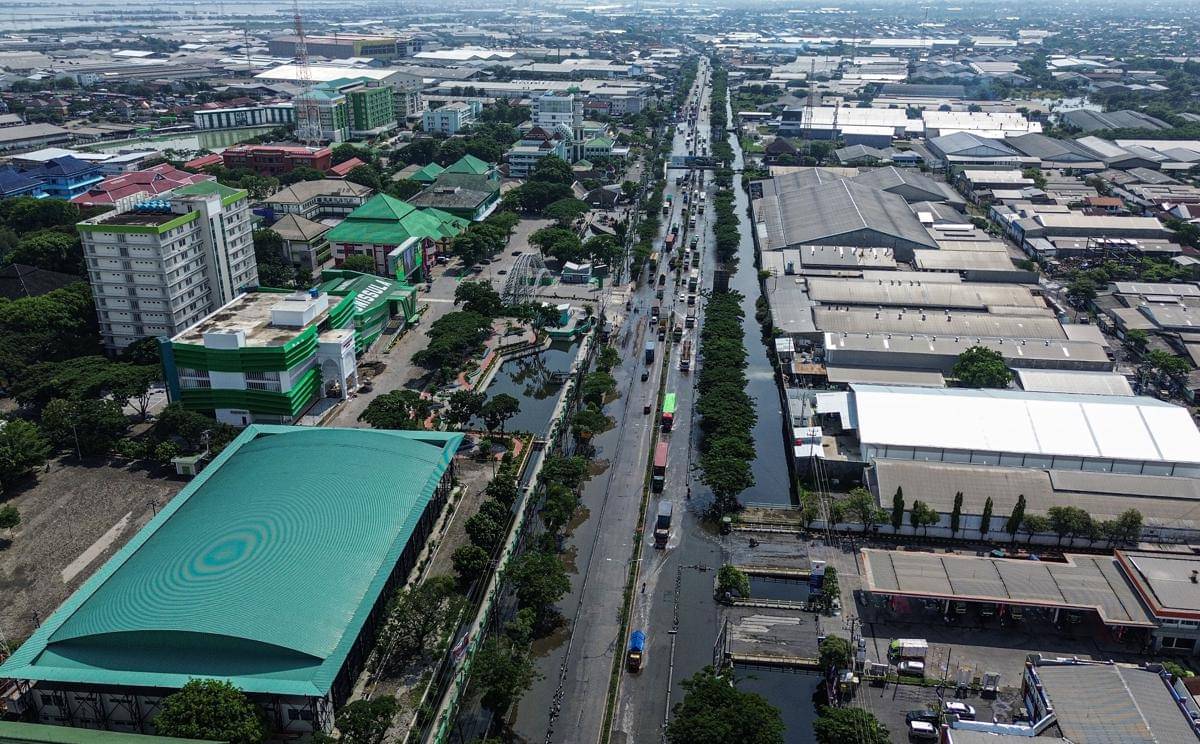 Foto udara sejumlah kendaraan melintasi banjir yang masih menggenangi jalur utama pantura Semarang-Surabaya di Jalan Kaligawe Raya, Semarang, Jawa Tengah, Senin (27/10/2025). (Antara/Makna Zaezar)