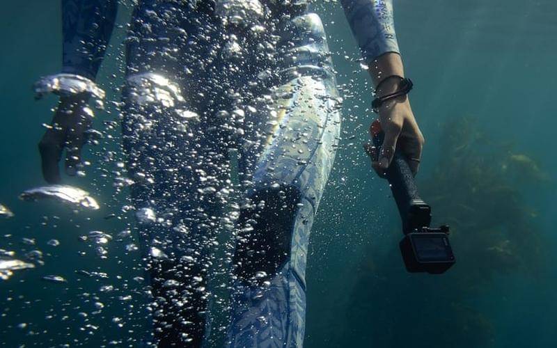 ilustrasi pemasangan floating camera hand grip saat berenang