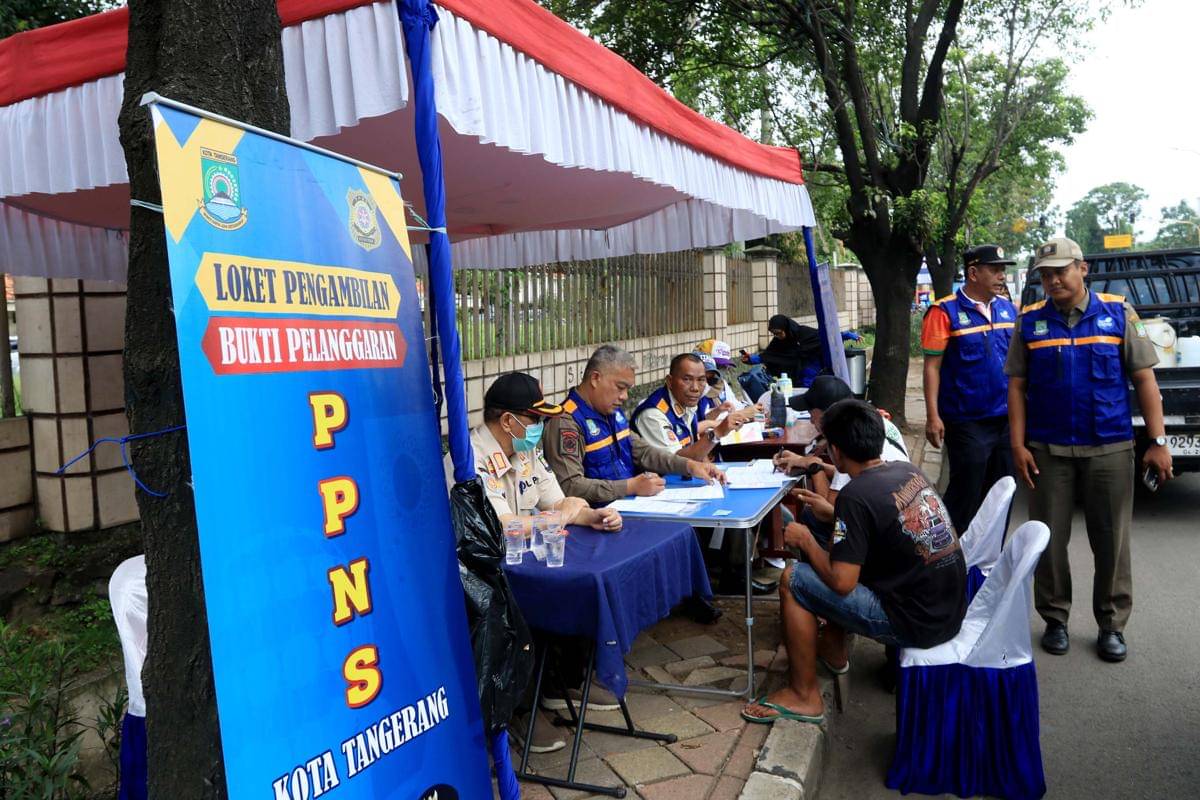 Pengendara mengambil surat pelanggaran uji emisi di Kota Tangerang