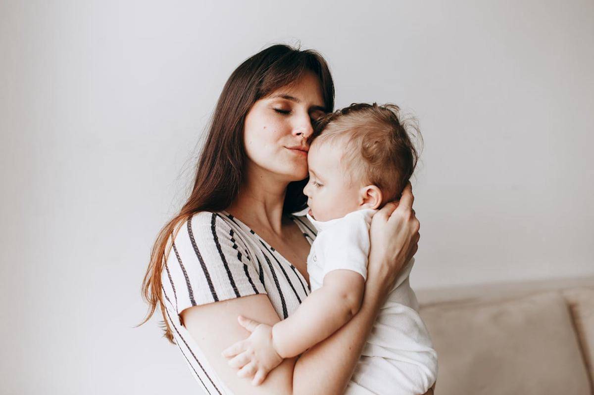 Seorang ibu menggendong bayinya.