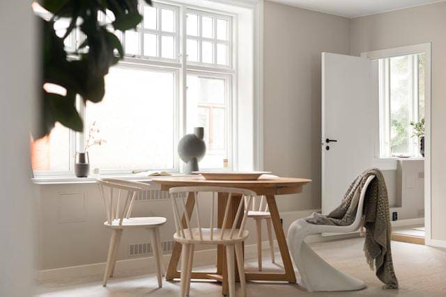 Sebuah ruangan dengan meja, kursi, dan tanaman pot