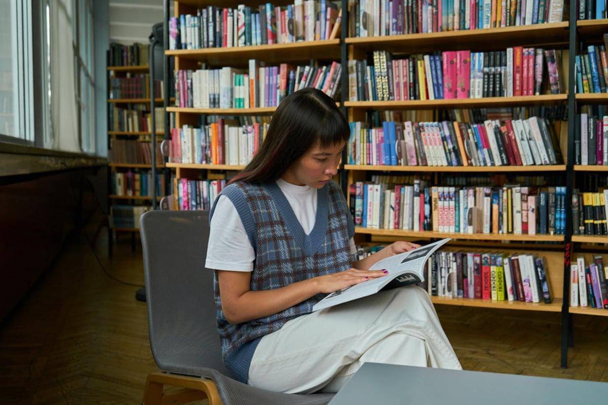 ilustrasi seseorang yang sedang membaca buku di perpustakaan