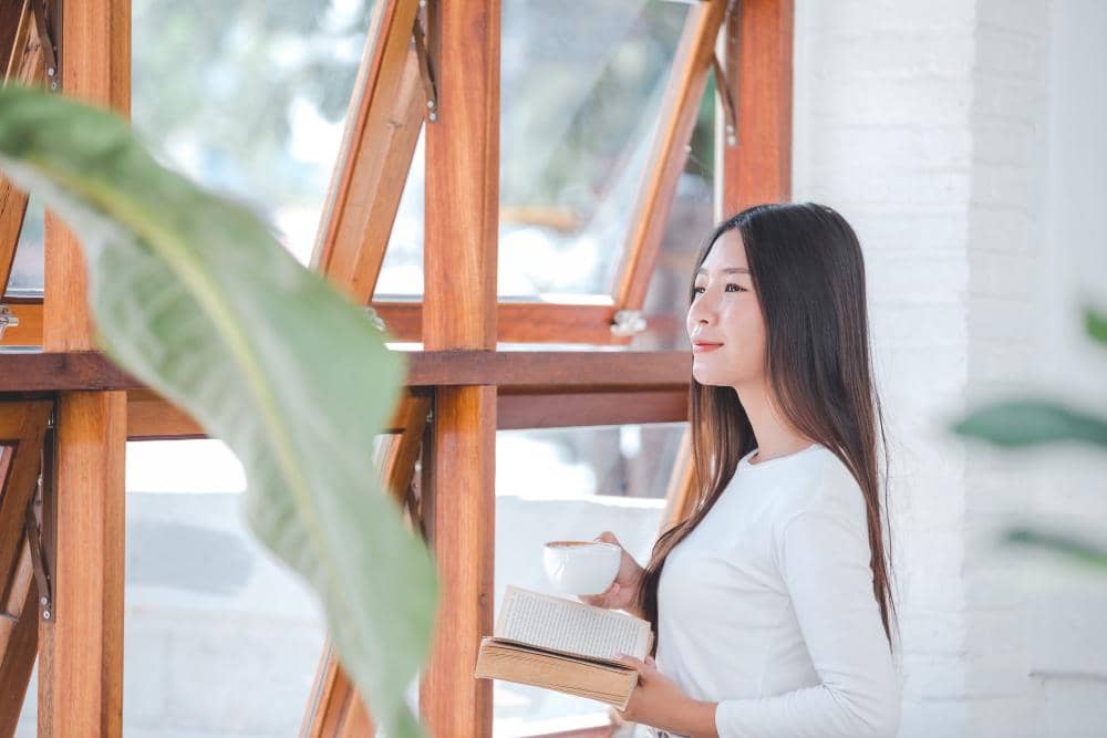 Perempuan di coffee shop menghadap jendela