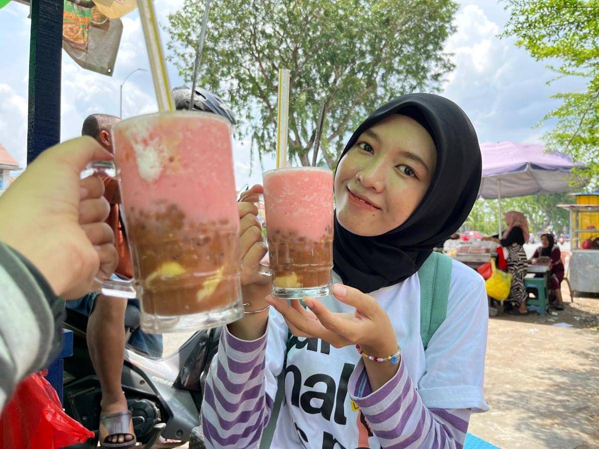 Pembeli Es Mamang Legend sedang menikmati es.