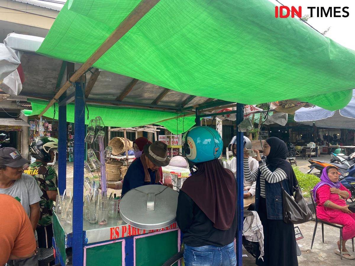 Pembeli Es Mamang Legend sedang menikmati es.