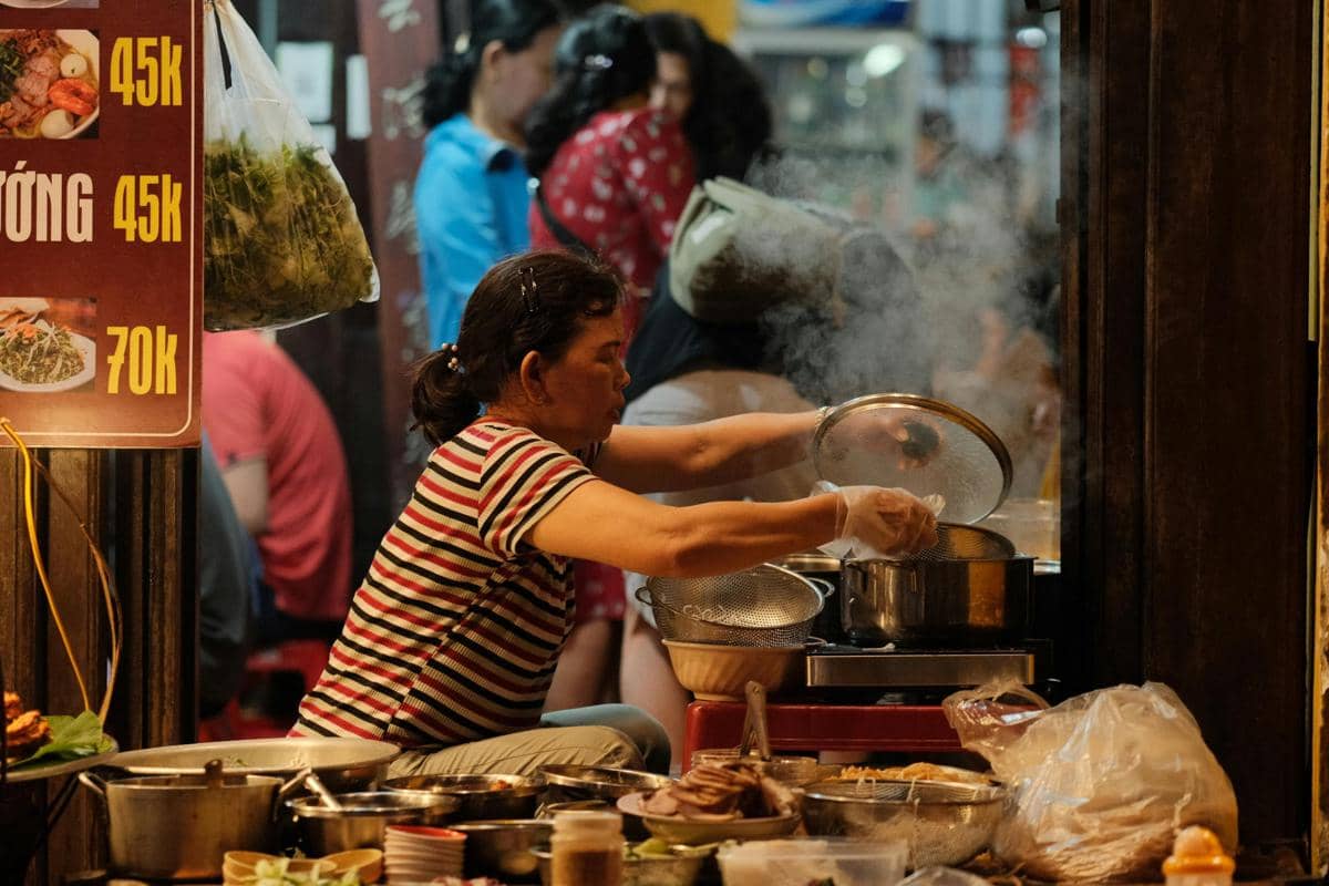 Foto pedagang kaki lima yang sedang memasak di pasar malam oleh Pew Nguyen di Pexels