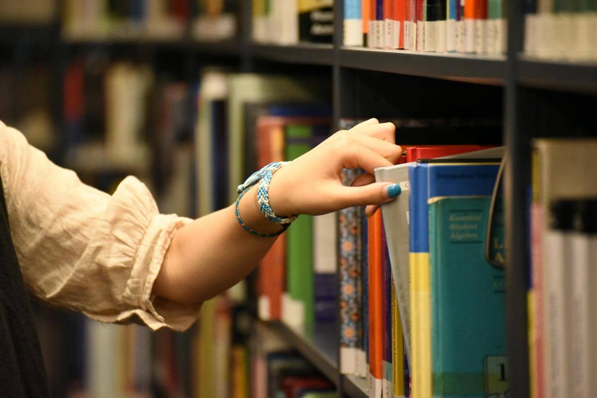 Ilustrasi seseorang sedang memilih buku 