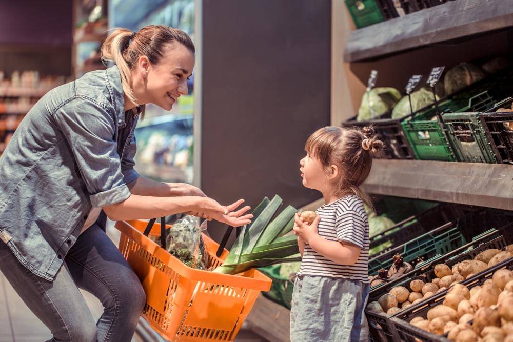 Ilustrasi ibu dan anak belanja di supermarket.