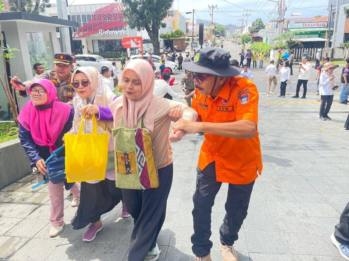 Simulasi Petugas BPBD Padang membantu warga untuk melakukan evakuasi.