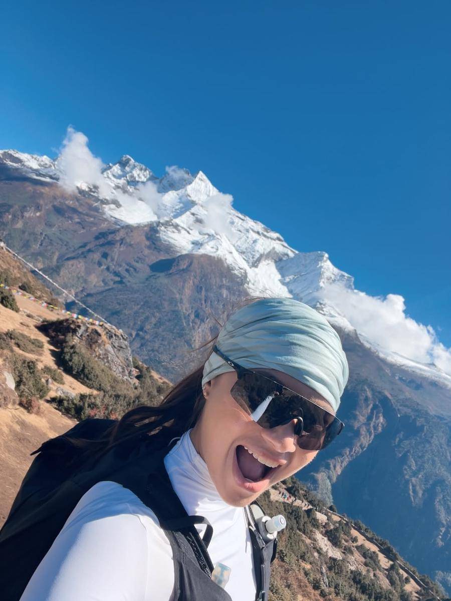 Angela Gilsha berpose di puncak gunung