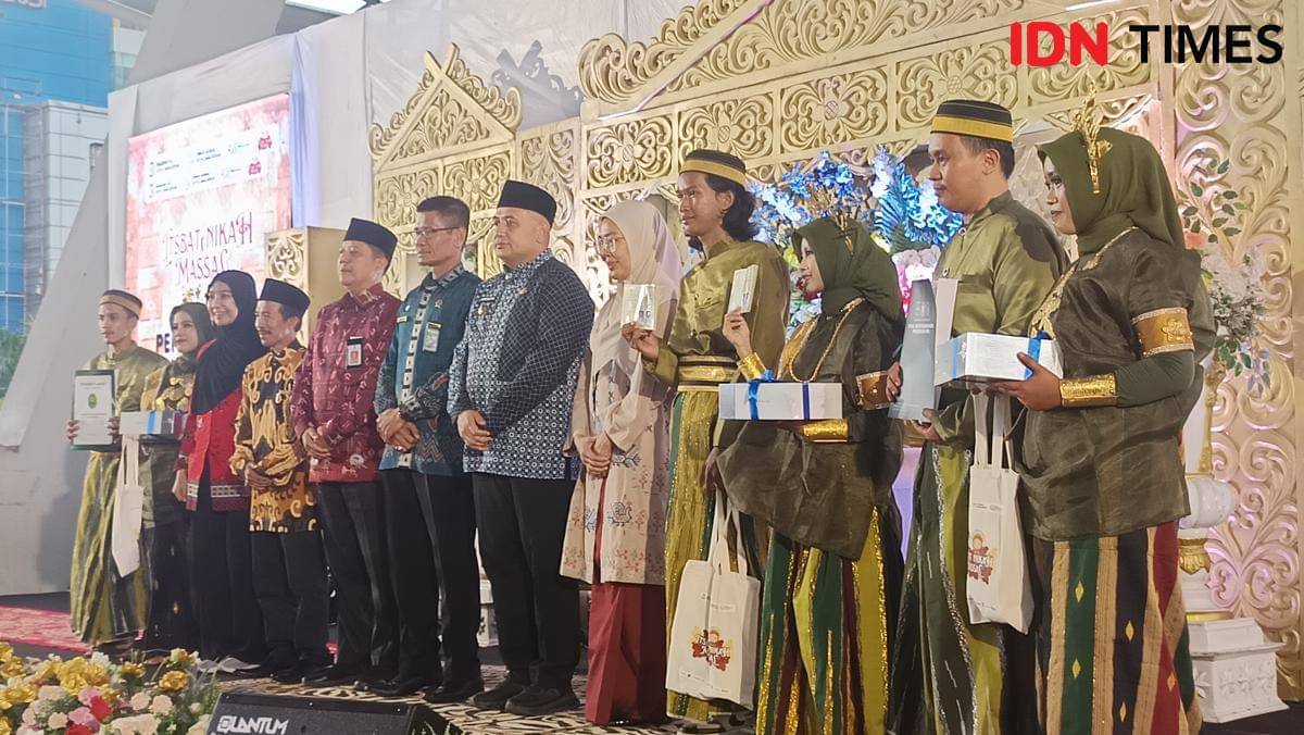 Wali Kota Makassar Munafri Arifuddin berfoto bersama peserta itsbat nikah massal di Tribun Lapangan Karebosi, Jumat (7/11/2025). (IDN Times/Asrhawi Muin)