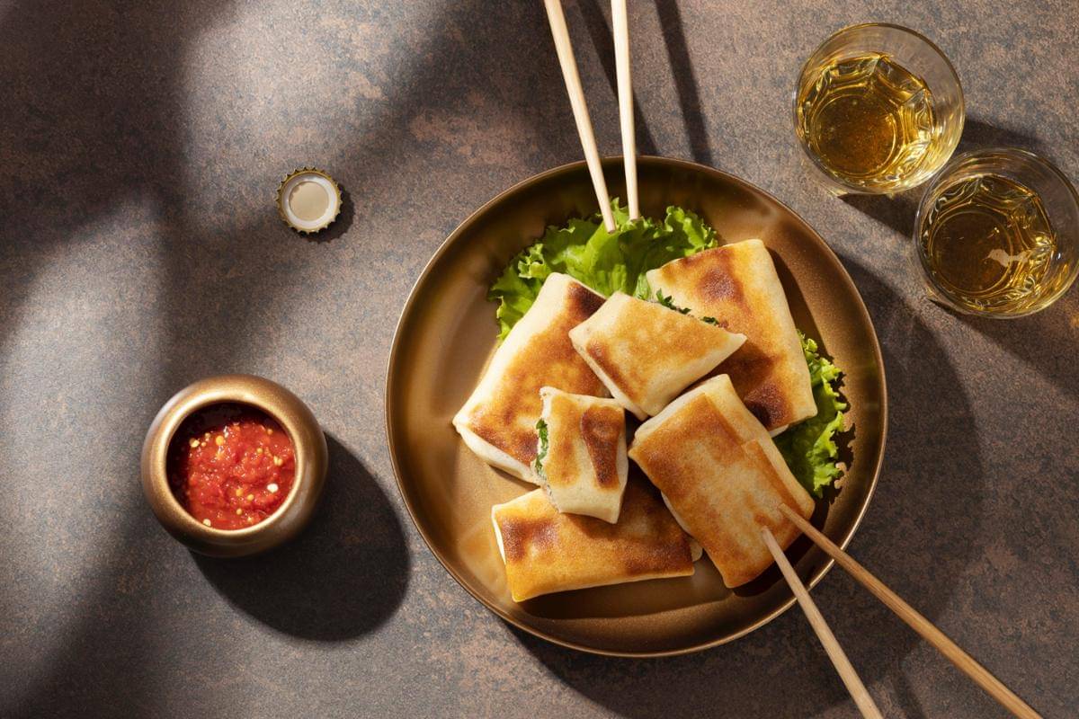 ilustrasi lumpia isi smoked beef keju yang disajikan bersama saus 