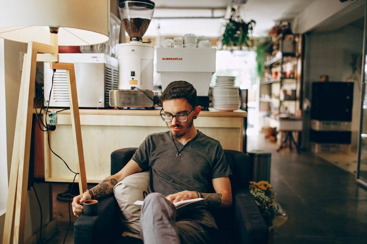 ilustrasi pria membaca buku di kedai kopi