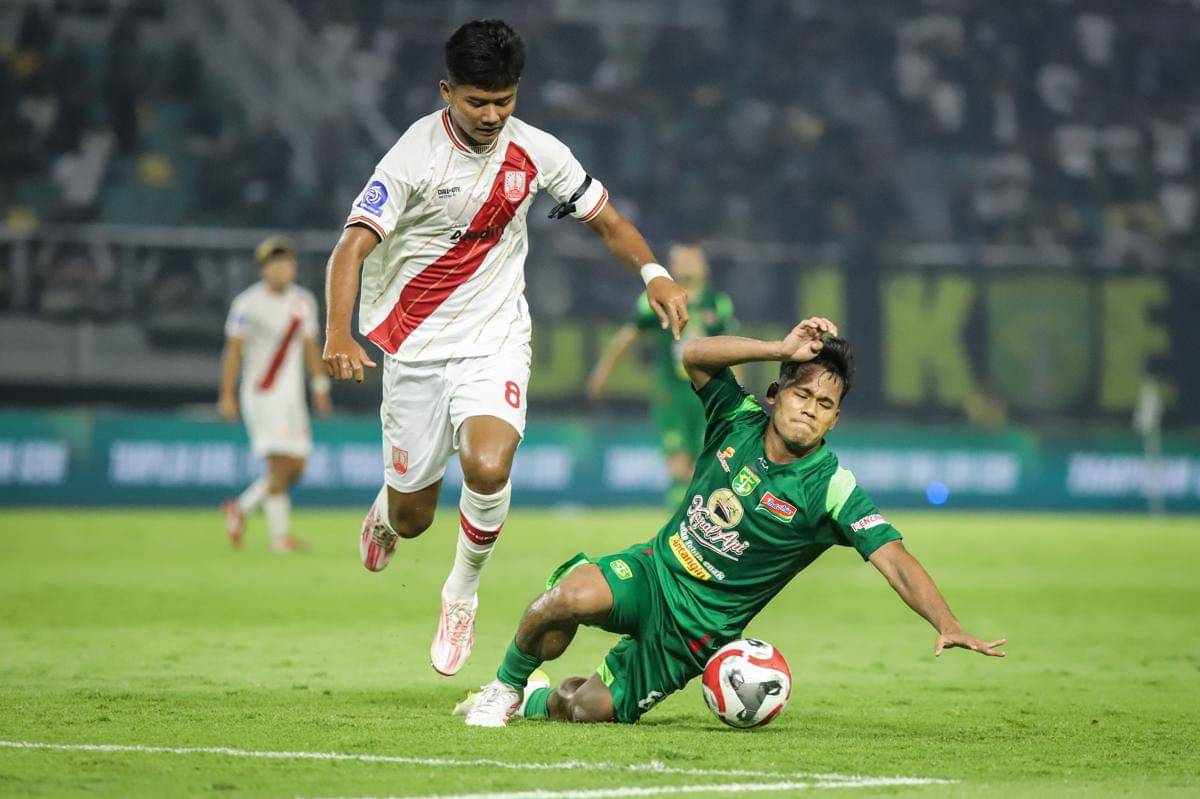 Pesepak bola Persebaya Surabaya Toni Firmansyah (kanan) terjatuh usai berebut bola dengan pesepak bola Persis Solo Arkhan Kaka (kiri) pada pertandingan BRI Super League di Stadion Gelora Bung Tomo, Surabaya, Jawa Timur, Minggu (2/11/2025). (ANTARA FOTO/Rizal Hanafi)