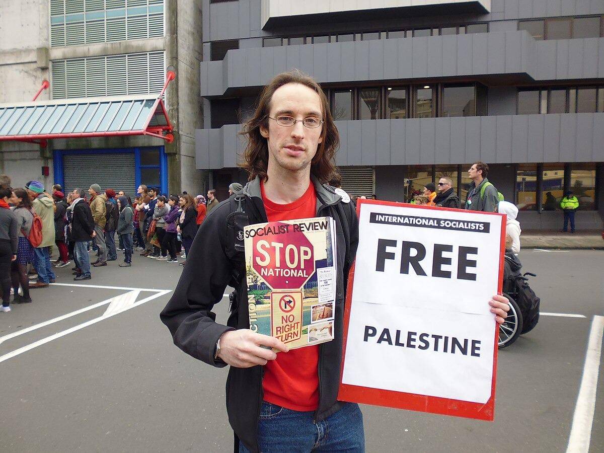 Seorang sosialis menjual majalah politik dalam aksi protes terhadap pengeboman Jalur Gaza oleh pasukan Israel, 2 Agustus 2014 (William Stadtwald Demchick, CC BY 3.0, via Wikimedia Commons)