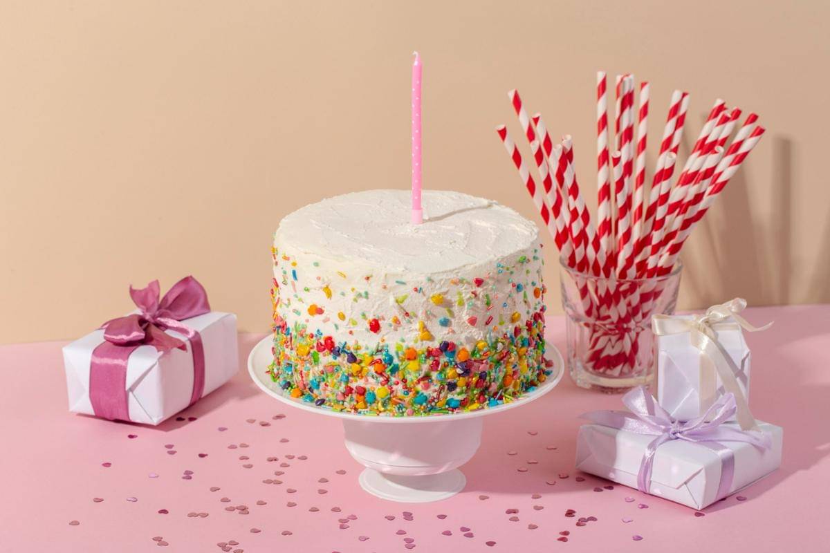 ilustrasi kue ulang tahun sederhana dengan whipped cream topping dan permen warna-warni