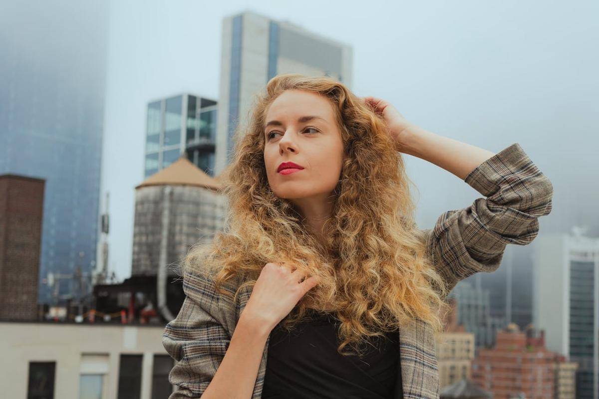 Seorang wanita sedang berdiri di depan gedung.