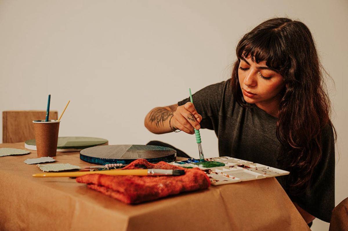 Seorang wanita sedang melukis.