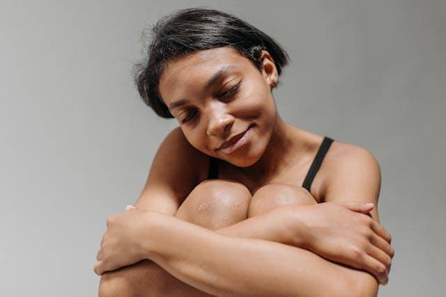 Ilustrasi seorang wanita memeluk diri sendiri 