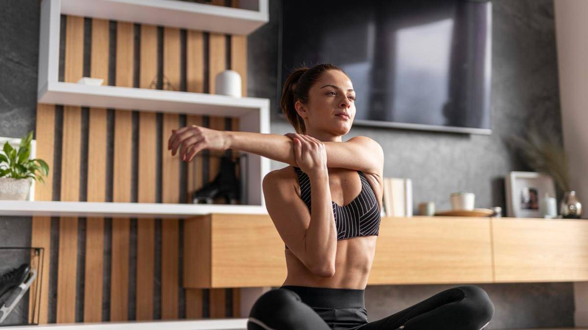 Seorang perempuan melakukan peregangan leher dan bahu.