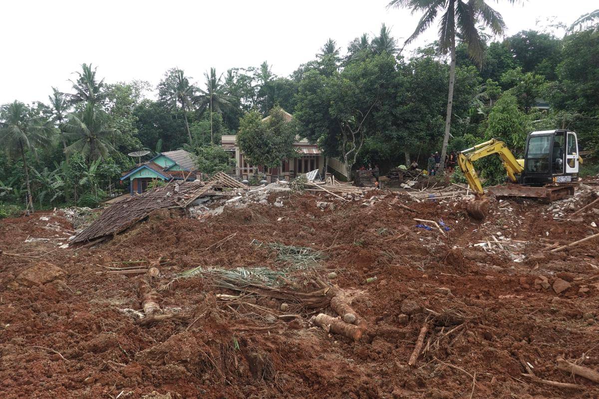Petugas dengan alat berat melakukan pencarian korban di kawasan yang terdampak tanah longsor hingga menimbun rumah warga di Desa Cibeunying, Majenang, Cilacap, Jawa Tengah, Jumat (14/11/2025). (ANTARA FOTO/Idhad Zakaria)