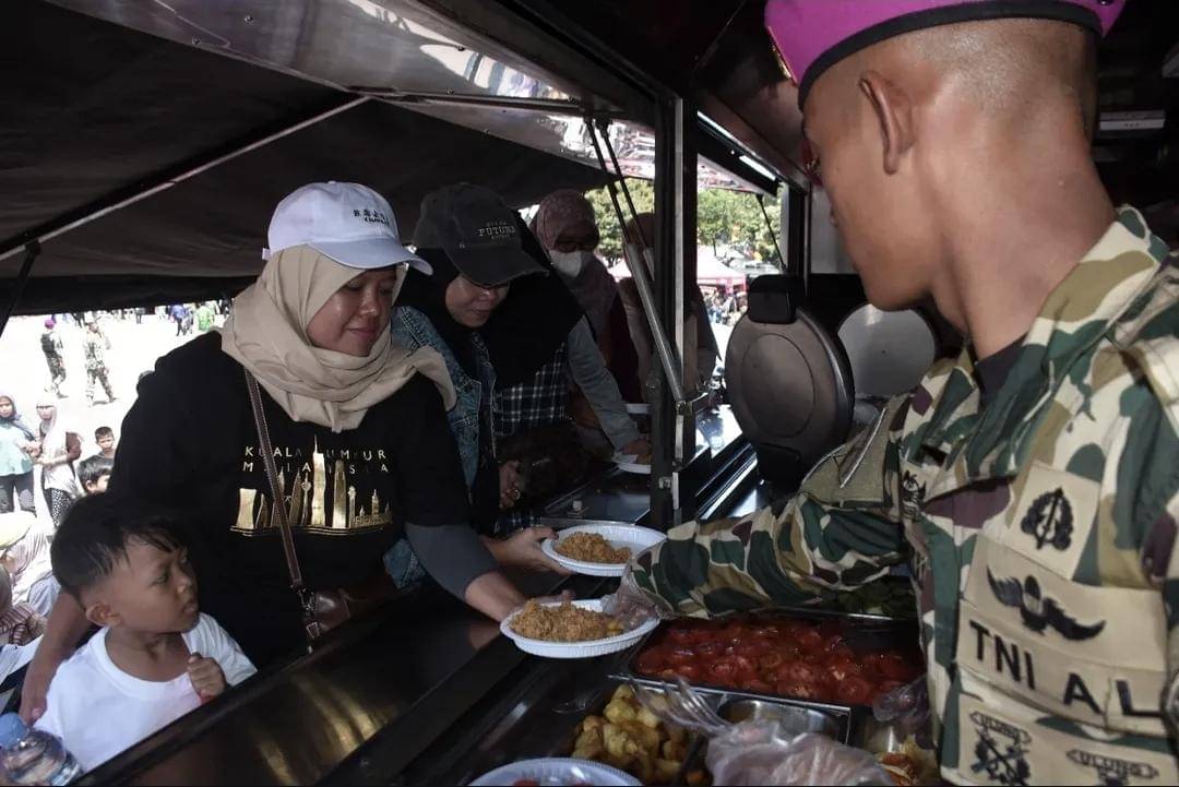 Prajurit marinir TNI Angkatan Laut (AL) ketika membagikan makanan gratis kepada warga