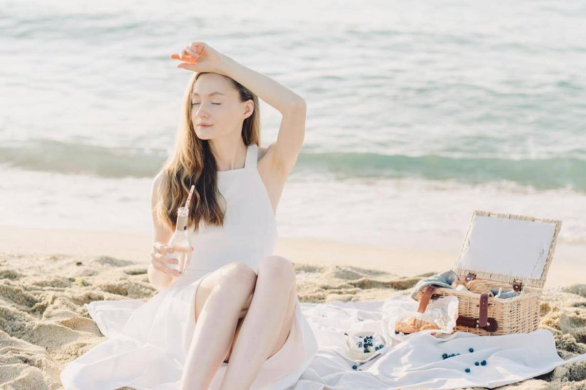 Seorang wanita sedang berada di pinggir laut.
