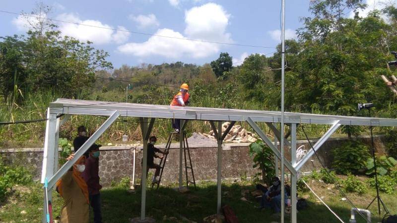 Fisikawan perempuan, Umi Salamah menaiki tangga saat mengecek konstruksi PLTS hibrid untuk pompa air di Desa Serut Kecamatan Gedangsari, Kabupaten Gunungkidul, Daerah Istimewa Yogyakarta (DIY). (Dok. Kalurahan Serut)