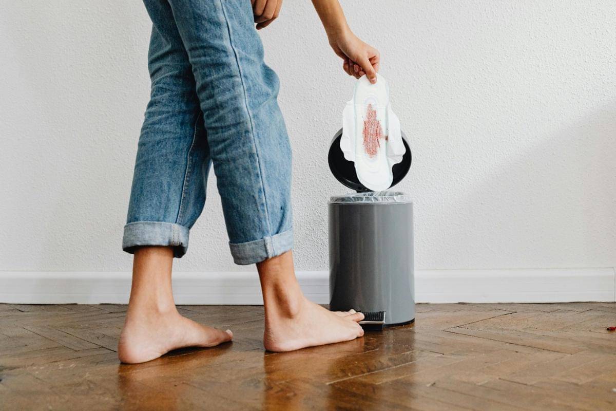 Seorang wanita membuang pembalut bekas pakai.