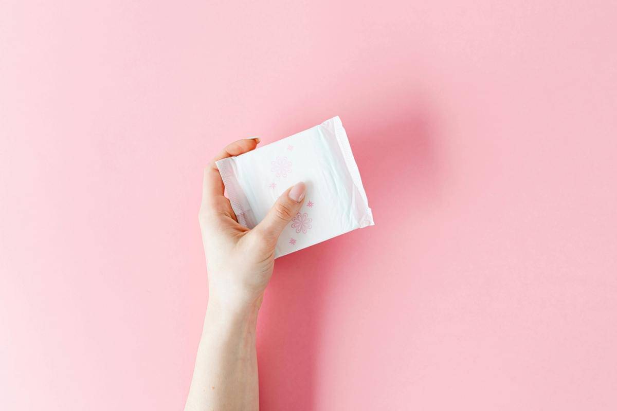 Pembalut menstruasi dipegang dengan satu tangan.