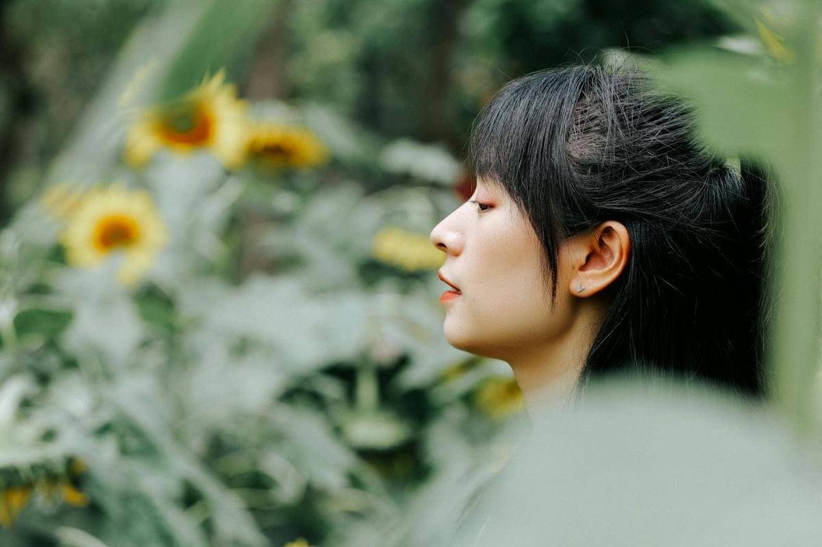 Seorang wanita sedang di kebun bunga.