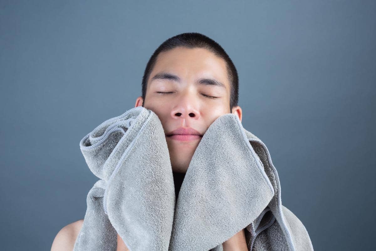 Ilustrasi kompres hangat bisul di wajah.