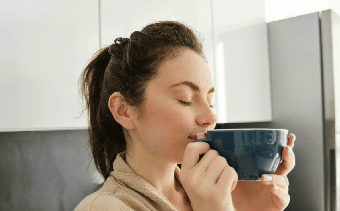 Potret orang mencium aroma kopi 