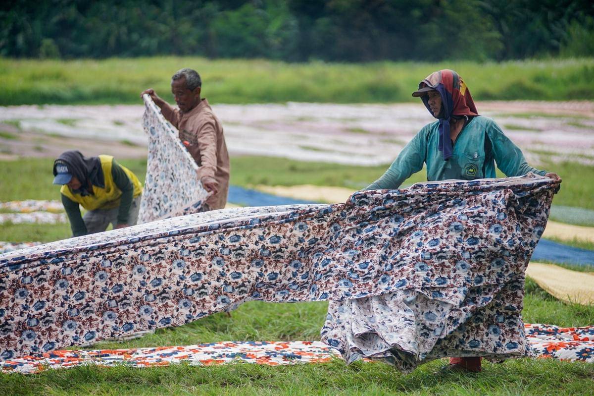 Pekerja menjemur kain batik di salah satu lapangan desa di Kota Pekalongan, Jawa Tengah. (ANTARA FOTO/Harviyan Perdana Putra)