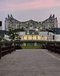 Tampak depan Gedung Kantor Presiden IKN pada sore hari dengan pencahayaan menyala.