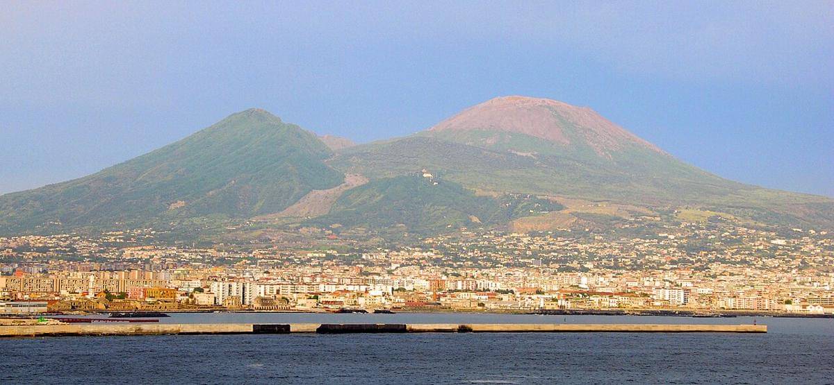 Gunung Vesuvius dari kejauhan, menampakkan permukiman padat yang mengelilingi kaki gunung berapi yang dorman.