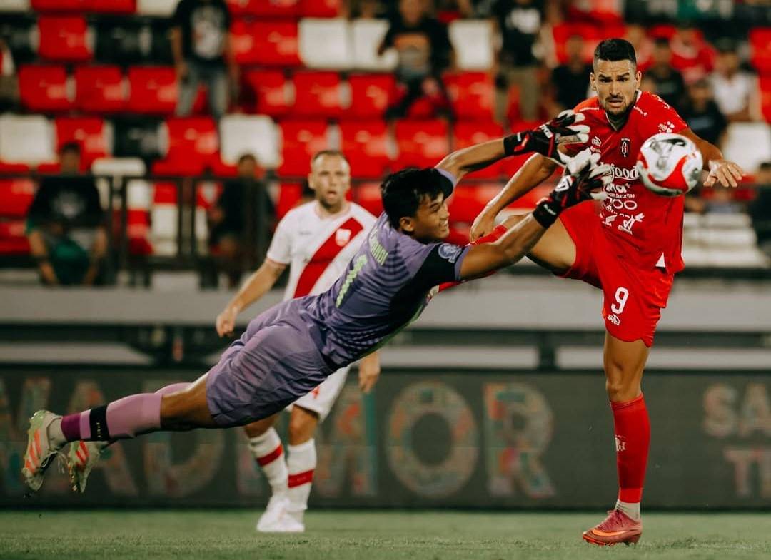 Boris Kopitovic (merah) saat berebut bola dengan penjaga gawang Peris Solo (ungu)