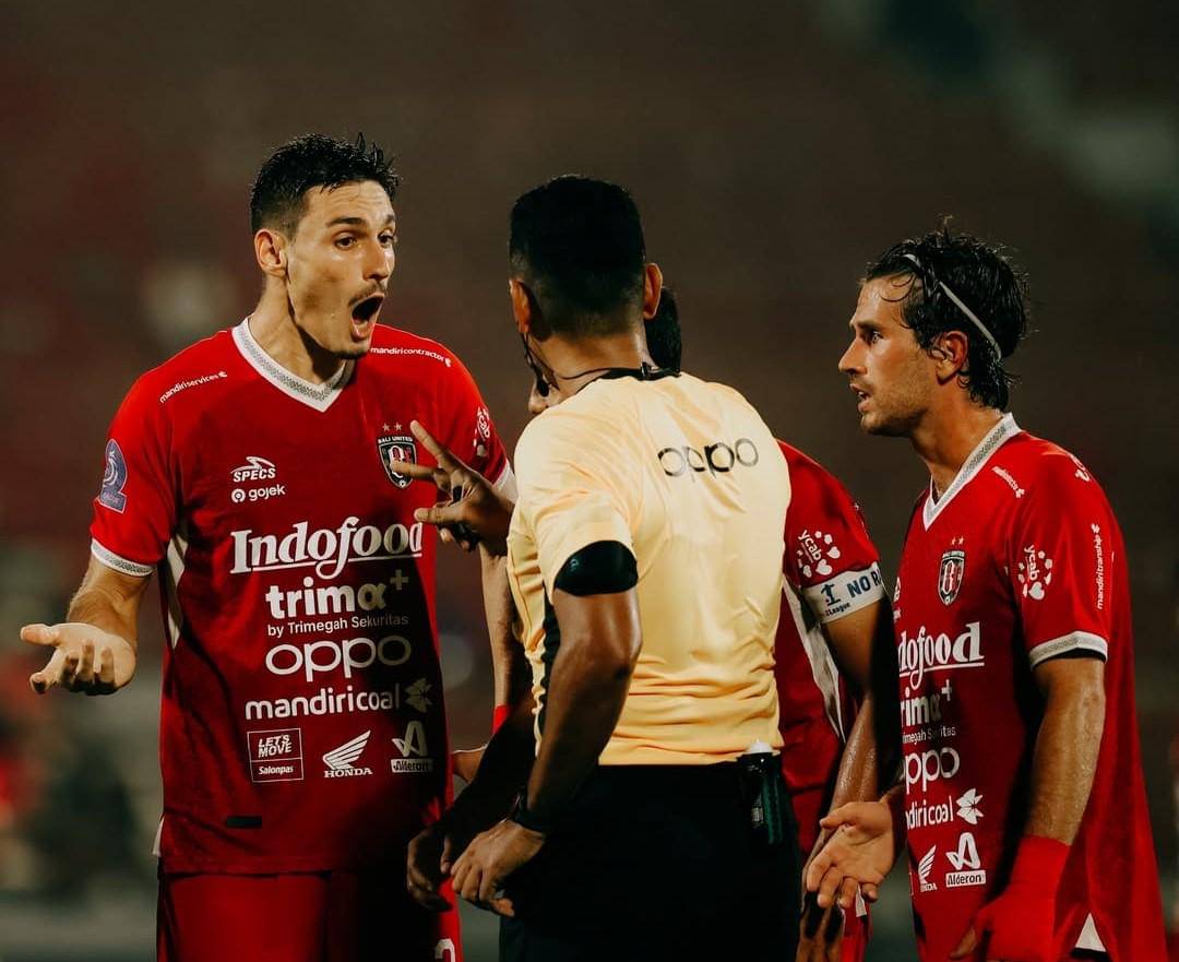 Pemain Bali United (merah) saat berdiskusi dengan wasit. 