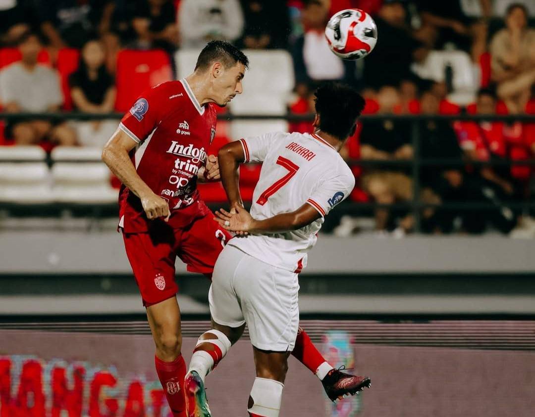 Pemain Bali United (merah) saat berebut bola dengan pemain Persis Solo (putih).