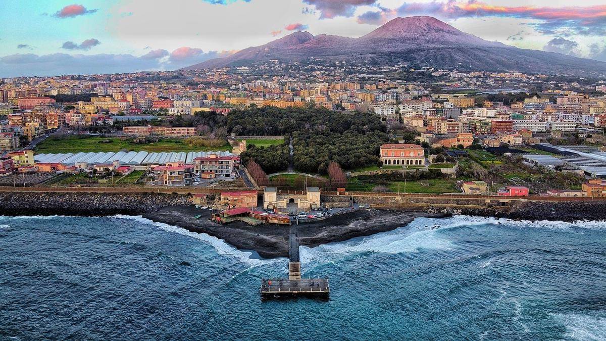 Pemandangan modern kota di sekitar Teluk Napoli yang hidup berdampingan dengan Gunung Vesuvius di latar belakang.