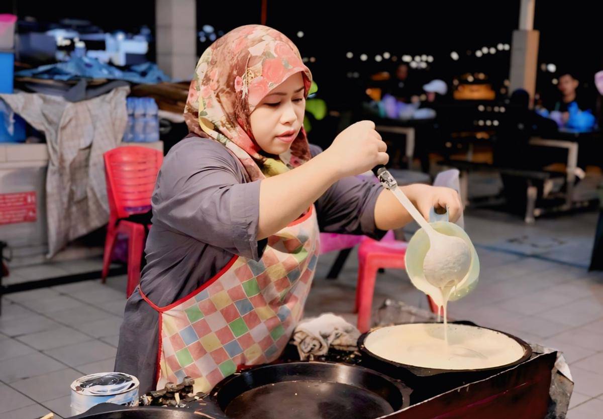 ilustrasi menuang adonan martabak ke wajan