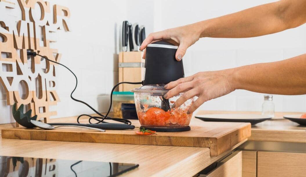 Ilustrasi blender berisi aneka rempah untuk menghaluskan bumbu masakan, dengan bahan-bahan aromatik di sekelilingnya.